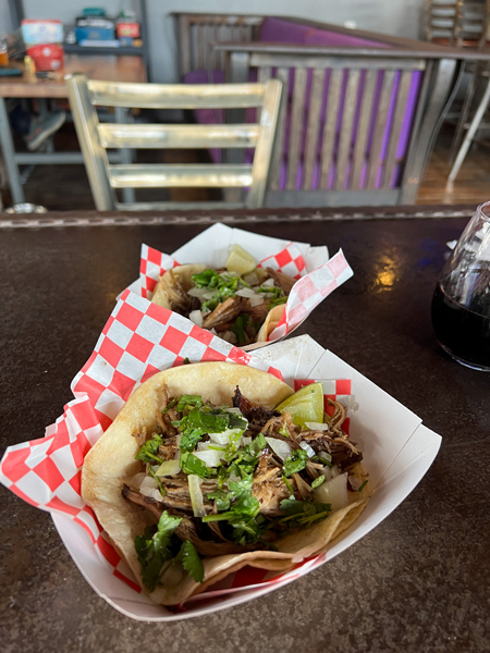 The Grey Eagle Taqueria at Big Pillow Brewing in Hot Springs NC with two tacos in takeaway paper trays filled with meat, lettuce, and limes