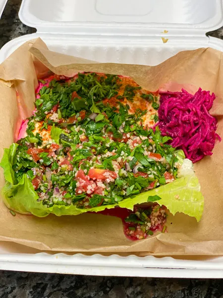 Gypsy Queen Cuisine Takeout in Asheville NC with Mediterranean-like salad with cilantro, red cabbage, tomato, and green lettuce