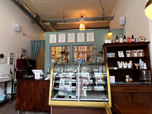 Ivy and the Poet Cafe in Marshall, North Carolina with display case filled with cookie, cakes, and pastries along with coffee station and menus on the wall