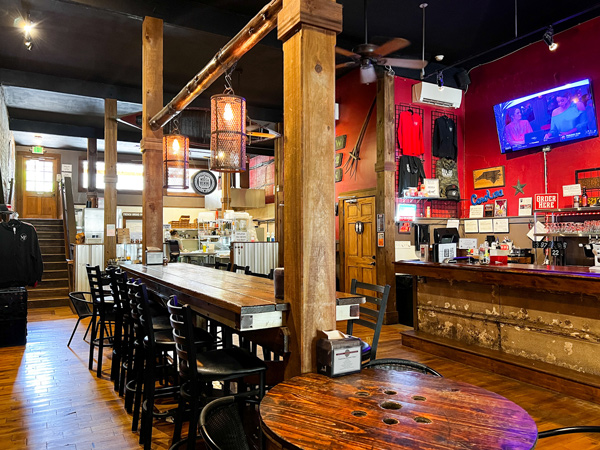 Mad Co. Brew House in Marshall NC with taproom, both regular and high top seating, bar, and pizza kitchen in the background