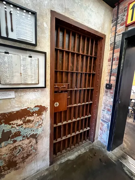 Zadie's Market at the Old Marshall Jail in NC with image of former jail bars and framed pieces of paper from the former jail