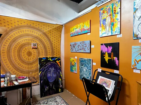Arrowhead Gallery & Studios Old Fort NC orange-walled studio with colorful abstract paintings for purchase