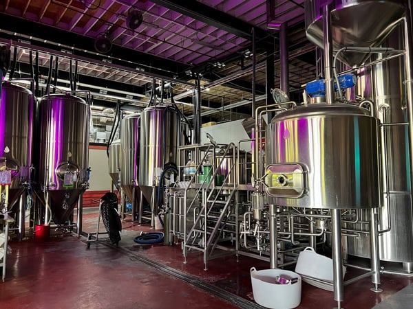 Hillman Beer Old Fort NC Taproom with steel fermentation tanks making the beer and fun purple lighting on them