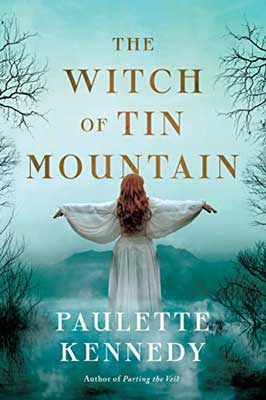 The Witch of Tin Mountain by Paulette Kennedy book cover with person in white with redish hair overlooking foggy blue mountain range