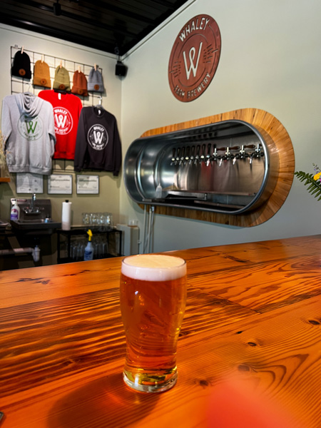 Whaley Farm Brewery Old Fort NC taproom with amber colored beer in bar counter with taps and logo in background