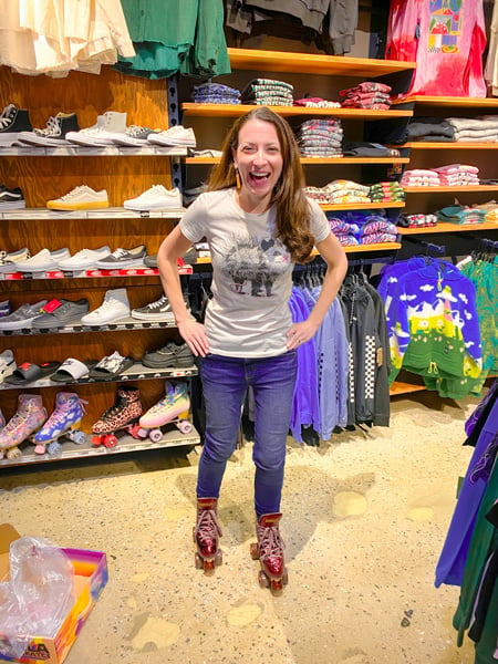 Asheville Mall Zumiez Store Asheville NC with white brunette female in jeans and tshirt trying on maroon roller skates