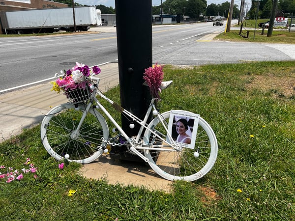 Carli Brewer Soukup Memorial along the Swamp Rabbit Trail with bike painted in white with flowers in basket