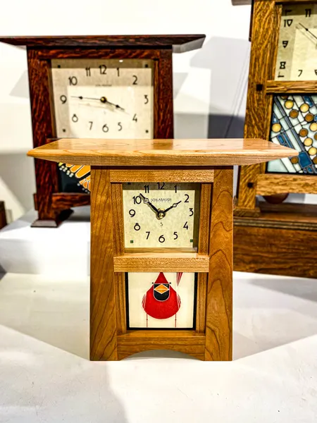 Grovewood Gallery in Asheville NC Shop with wooden clocks on display; clock in front has a red cardinal design on it