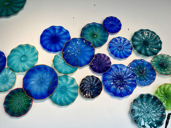 Lexington Glassworks in Downtown Asheville NC wall display of blue and green discs made from blown glass