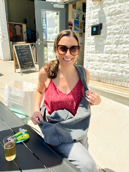 Oklawaha Brewing Company in Hendersonville NC Gluten Reduced Brewery with white brunette female in sunglasses and red tank with avocado plush cat toys and glass of light yellow beer