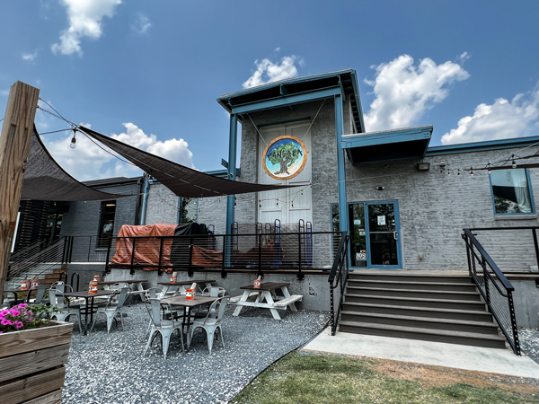 Pangaea Brewing Company in Greenville SC Taproom with gray facade with blue trim along with tree logo and outdoor table seating