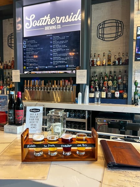 Southernside Brewing Co in Greenville, SC Beer Flight with yellow to amber beers on bar top with taps and draft list in the background
