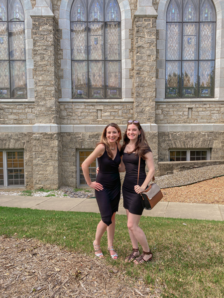 Candlelight Orchestra event in Asheville NC with two white brunette women in black dresses standing outside of beautiful old stone chuch