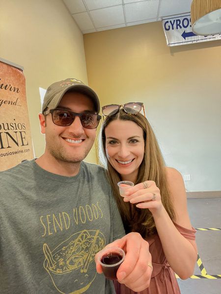 Asheville Greek Festival Wine Tasting with white brunette male and female holding plastic cups filled with red and white Greek wine