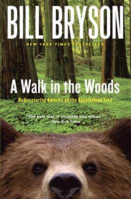 A Walk in the Woods by Bill Bryson book cover with brown bear face peeking over cover in green forest