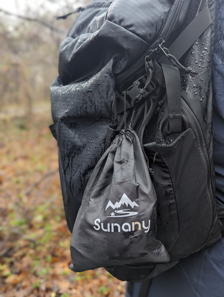 Black Sunany Female Urinal bag attached to black hiking backpack
