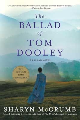 The Ballad of Tom Dooley by Sharyn McCrumb book cover with person in blue dress walking on green landscape with blue-white mountains in the distance