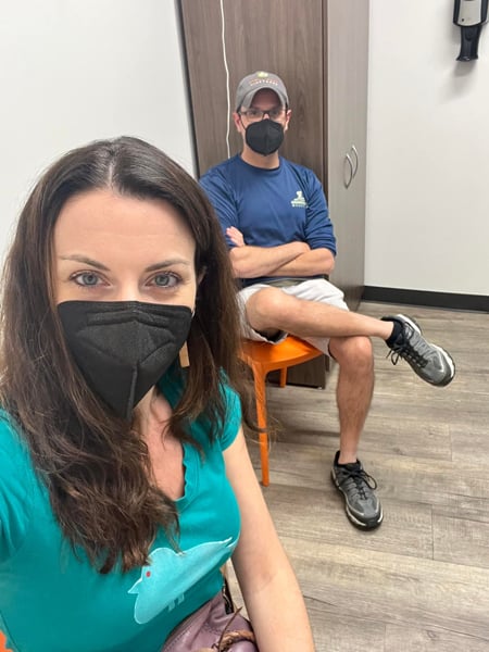 White brunette male and female sitting in Urgent Care in Asheville with masks on