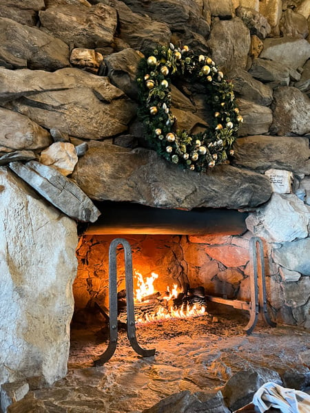 Large lit stone fireplace with holiday wreath at The Grove Park Inn in Asheville, NC