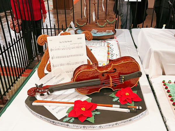 The Omni Grove Park Inn Gingerbread Houses display with close-up of brown violin with red flowers and sheet music