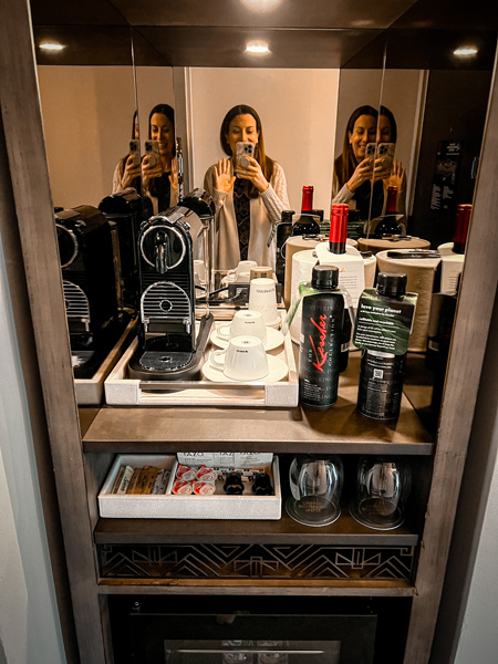 Photo of Christine, a white brunette female taking a picture of the coffeemaker and waters, at the Grand Bohemian Lodge Greenville