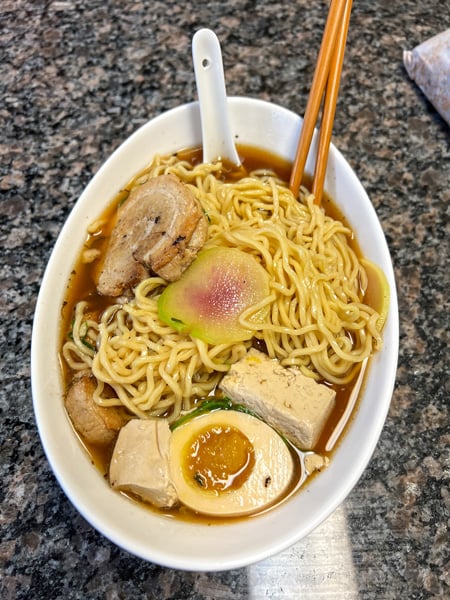 Delivery Ramen in our white bowl with noodles, tofu, egg, brown broth and vegetables from Gan Shan West in Asheville, NC