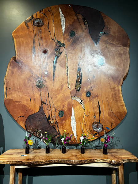 Lobby decor, a wood table with vases and large wooden wall hanging, at the Grand Bohemian Greenville