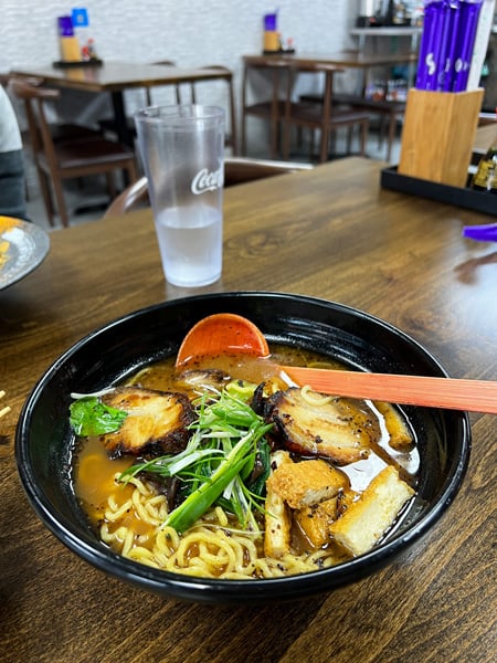 Large black bowl of ramen soup with noodles, pork, and vegetables from Mizu in Asheville, NC